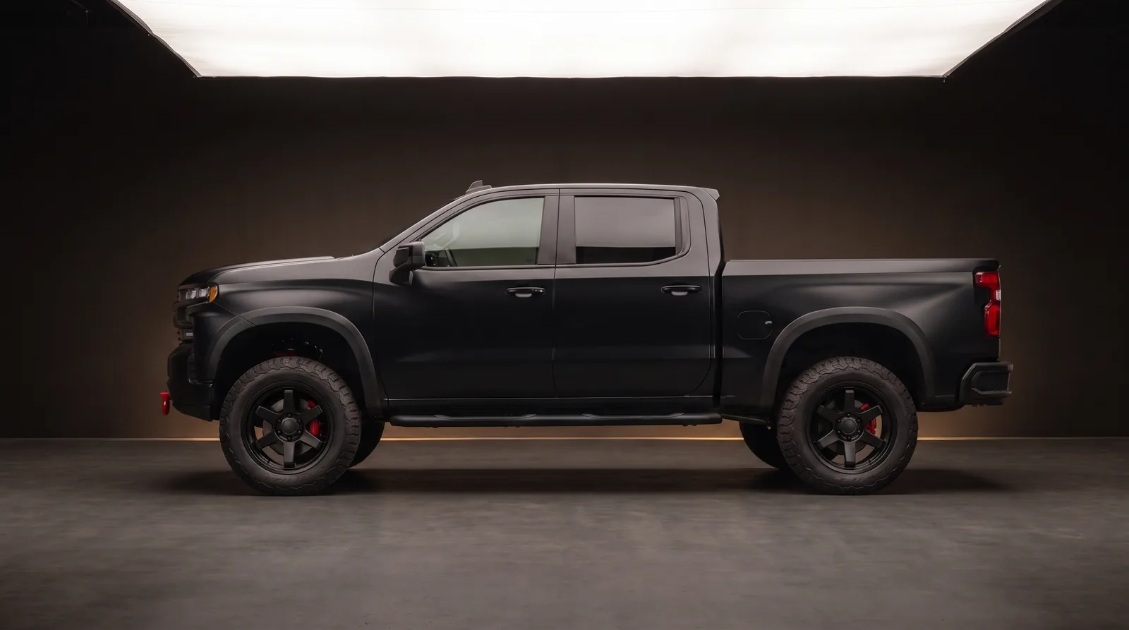 Lifted white pickup on black off-road wheels and all-terrain tires