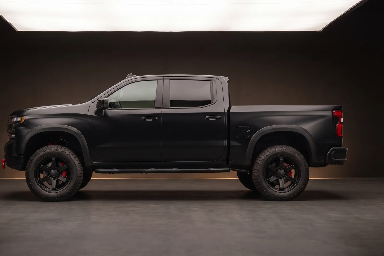 Lifted teal Toyota Tacoma on black aftermarket wheels at dusk