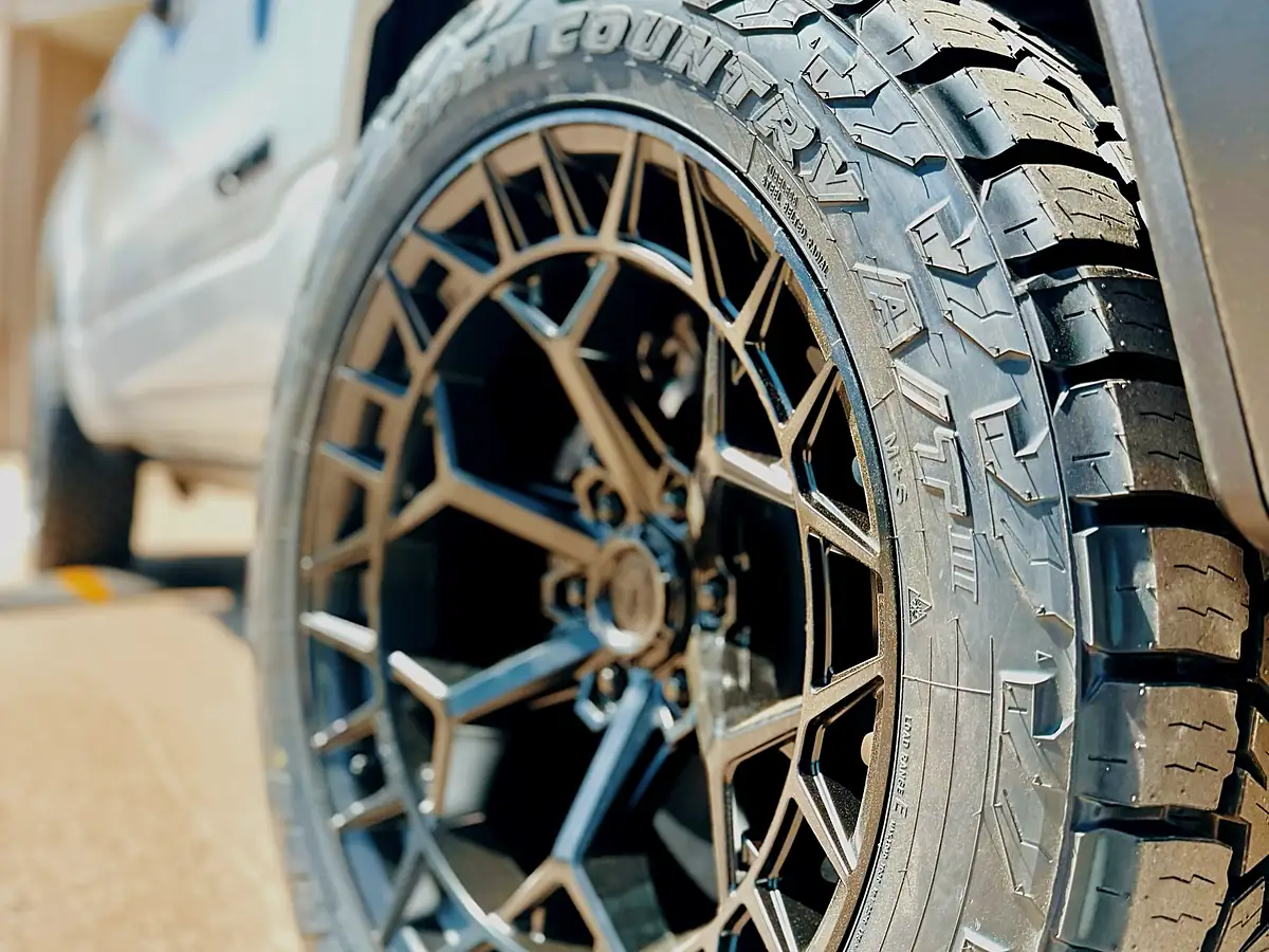 Close-up of a bronze Fuel wheel and Rough Country all-terrain tire on a lifted Ram 1500
