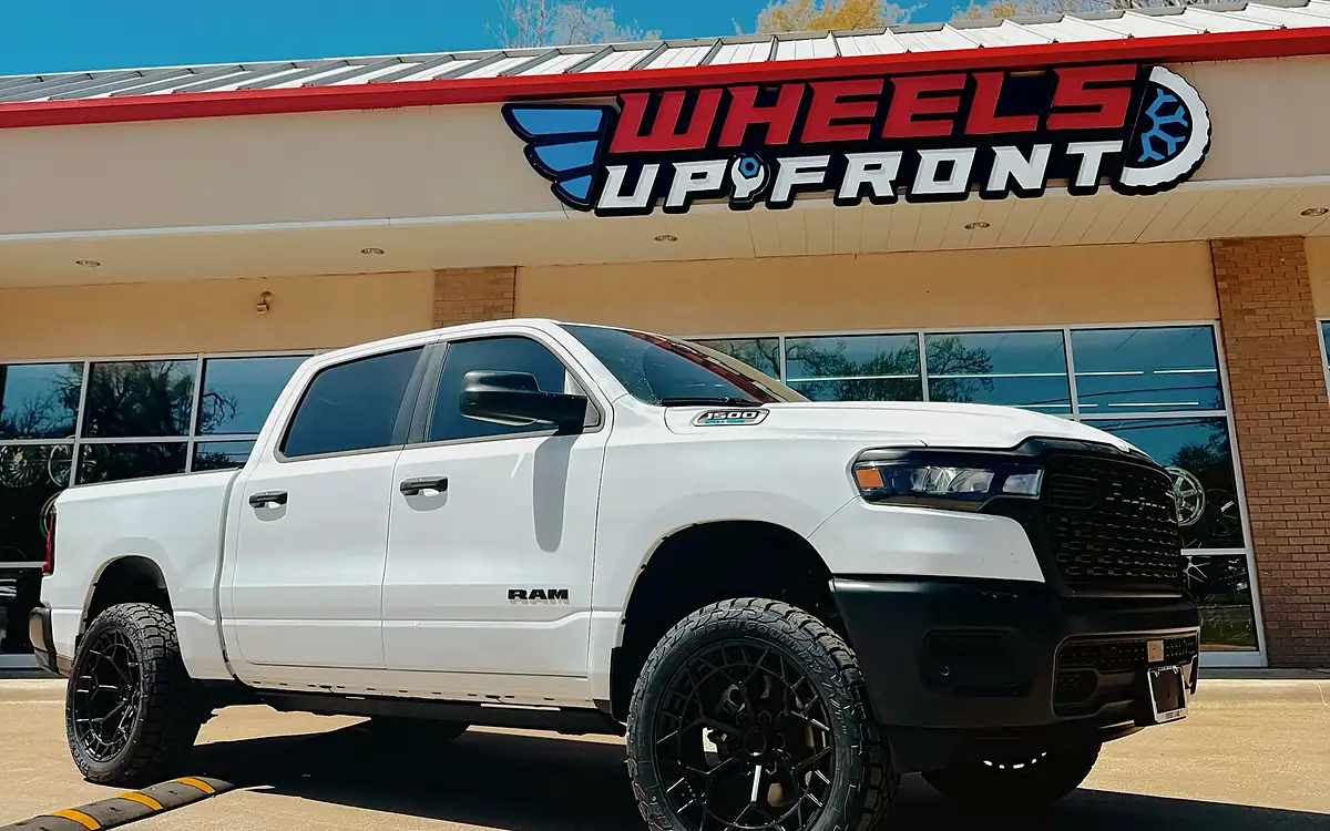 White Ram 1500 on a 3.5 inch Rough Country suspension lift with 22 inch Fuel wheels outside the Wheels Up Front shop in Tyler