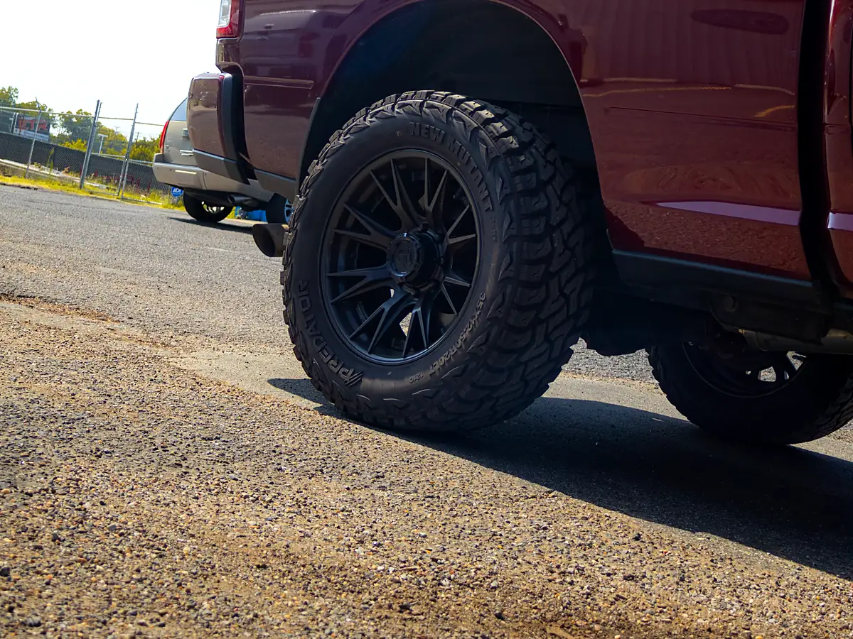 Rear wheel of a red 2023 Ram 2500 with a 2.5 inch Rough Country level on a black Fuel wheel and 35 inch Predator tire