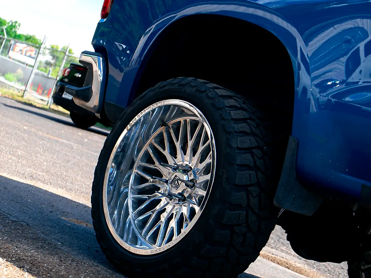 Lifted blue 2022 Chevy Silverado 1500 Z71 on chrome Axe wheels and mud-terrain tires