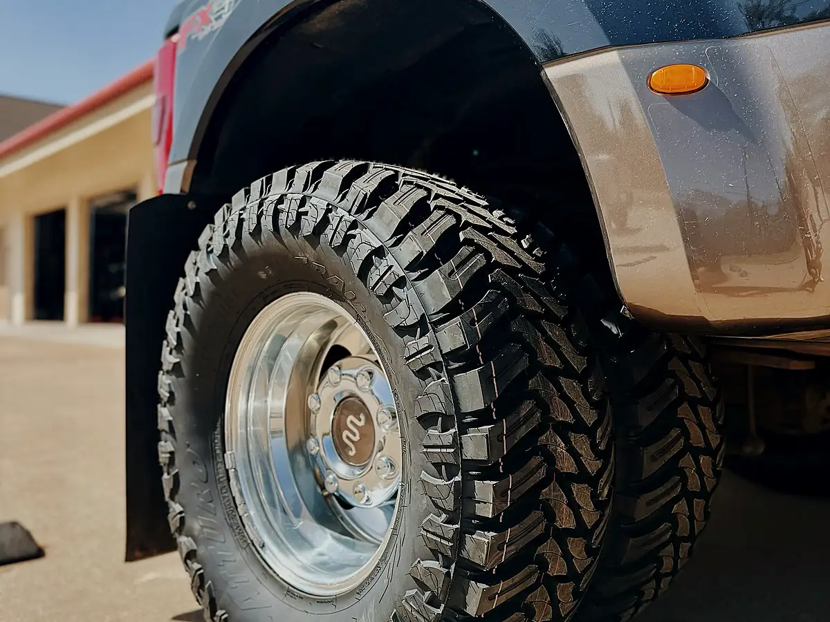 Mud-terrain tire on a polished dually wheel at the Wheels Up Front Tyler shop