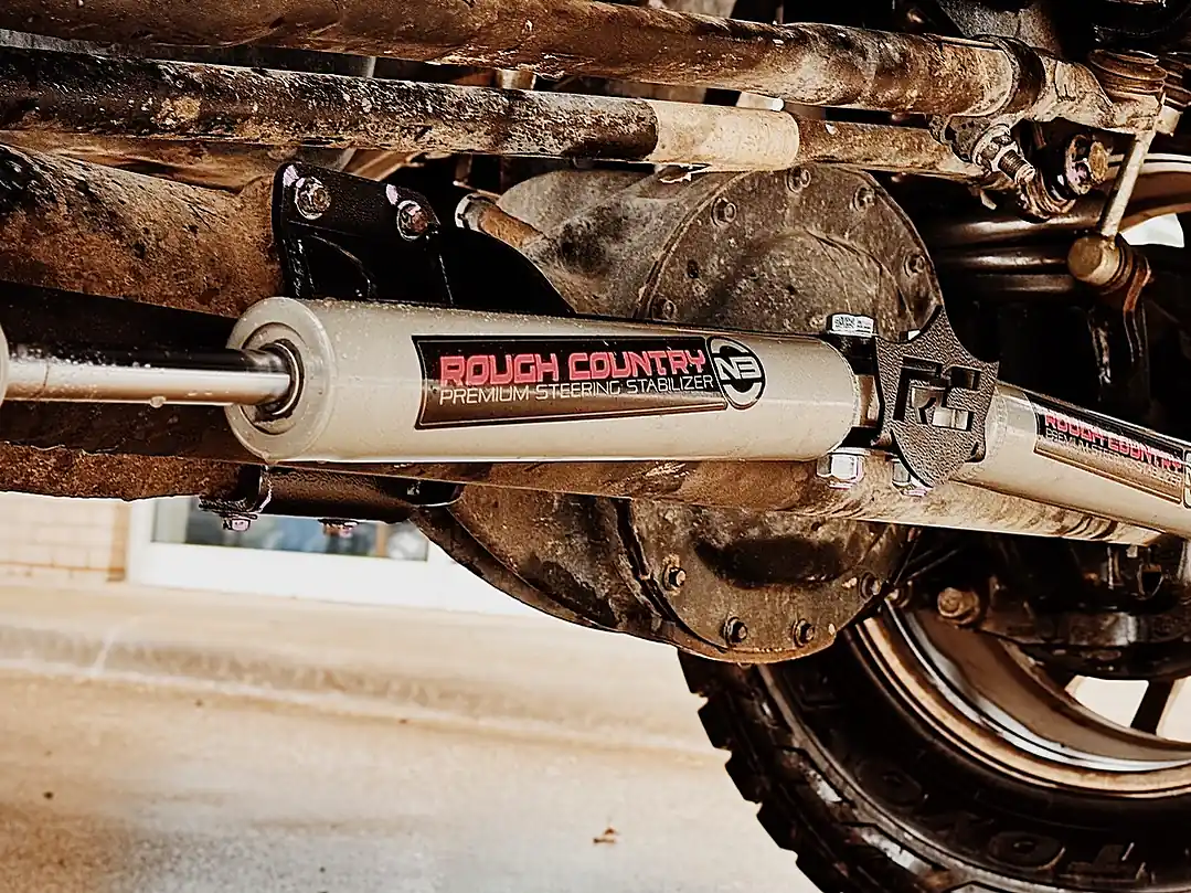 Rough Country steering stabilizer mounted on the front axle of a truck
