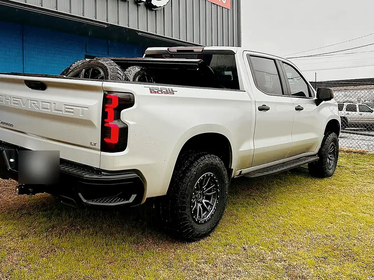Rear three-quarter view of a white Chevy Silverado ZR2 on black Fuel wheels and Toyo all-terrain tires