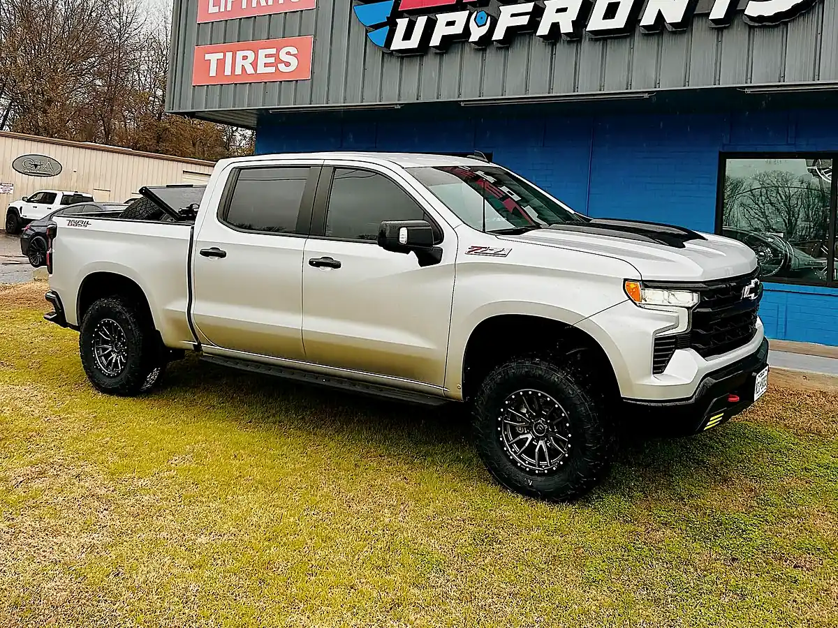 White Chevy Silverado ZR2 on black Fuel wheels and Toyo tires parked in front of the Wheels Up Front shop