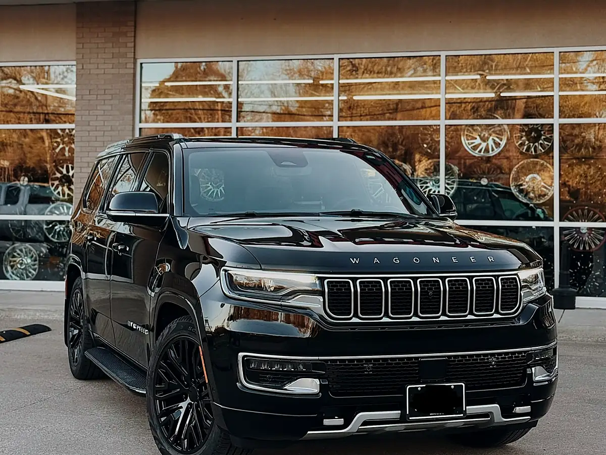 Black Jeep Wagoneer on black wheels in front of the Wheels Up Front shop in Tyler