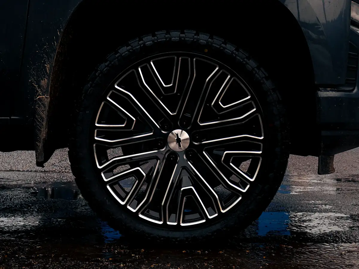 24 inch black and milled mesh wheel and Venom Power tire filling the front wheel well of a leveled Silverado