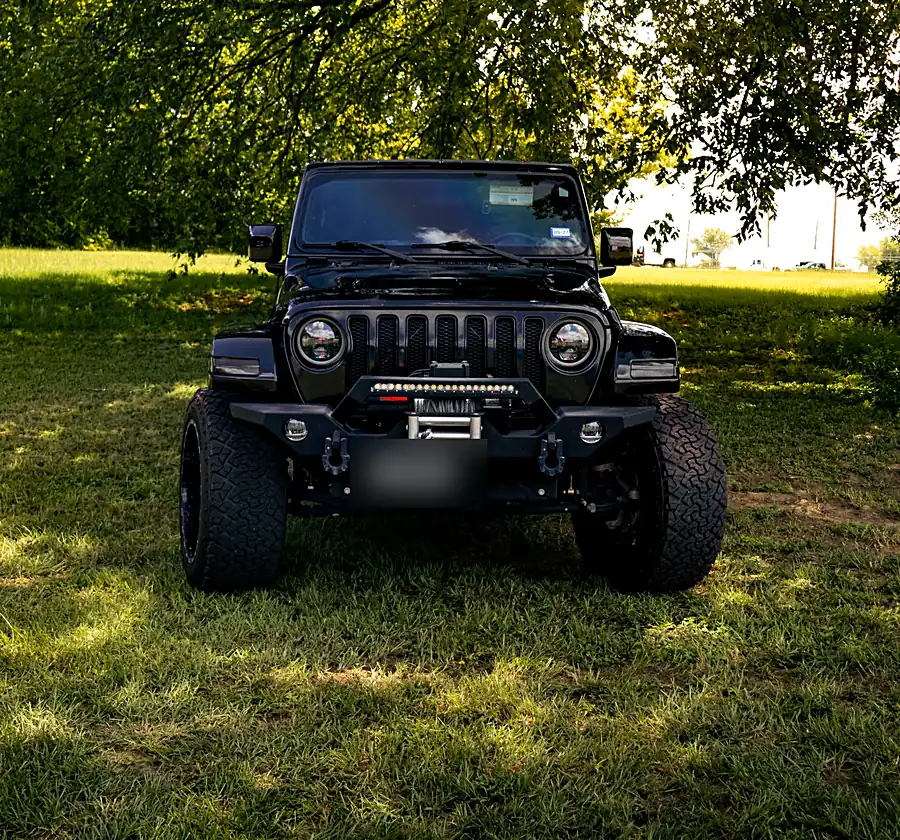 Black Jeep Wrangler with an aftermarket front bumper, winch and LED light bar