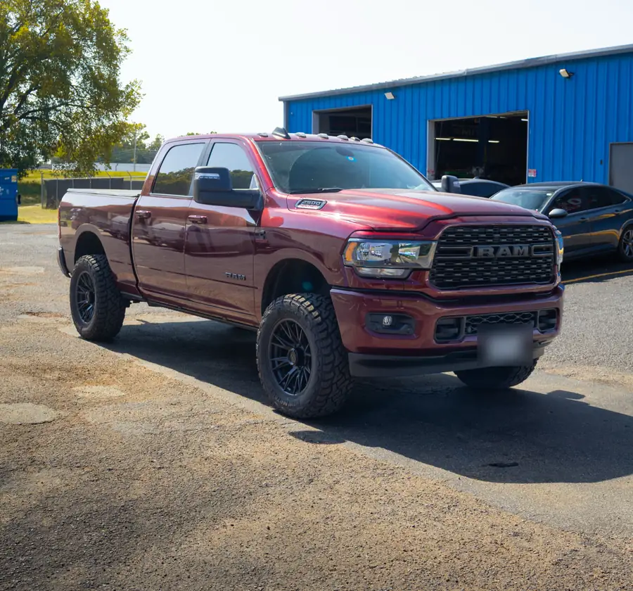 Red 2023 Ram 2500 with a 2.5 inch Rough Country leveling kit, 20x10 Fuel wheels and 35 inch tires outside the Wheels Up Front shop