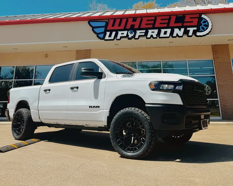 White RAM 1500 on a 3.5-inch Rough Country lift and black Fuel wheels outside the Wheels Up Front shop in Tyler